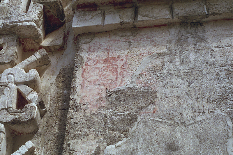Detail of red painted Maya hieroglyphs discovered on the stucco of Structure II
