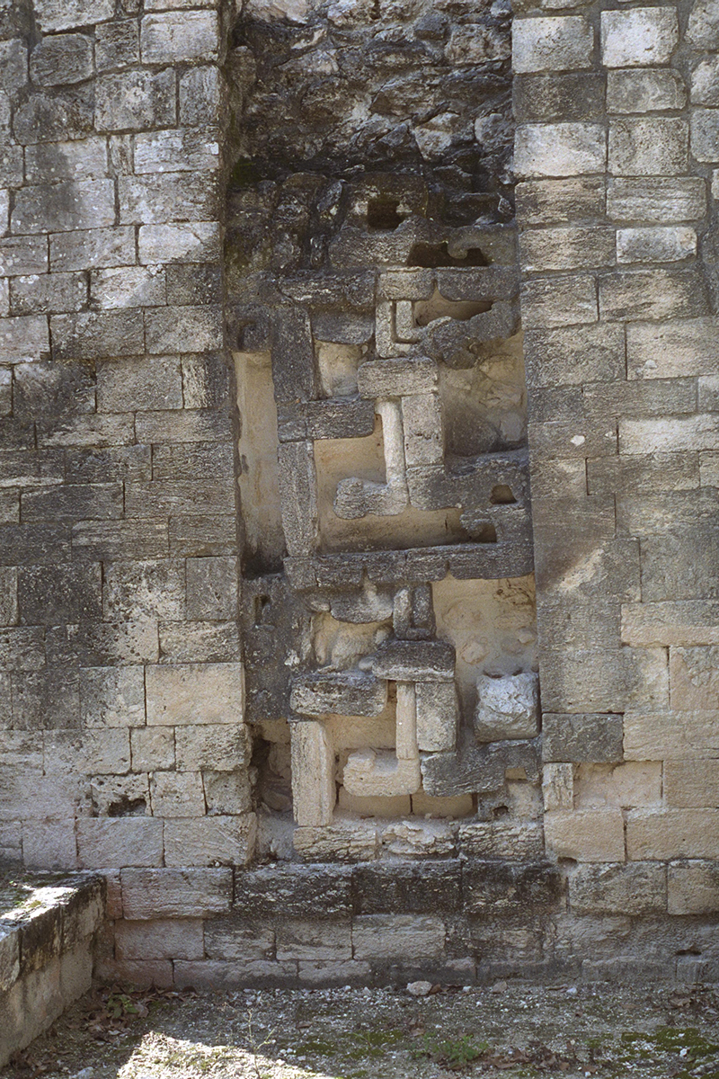 High-detail view of the stacked abstract serpent masks on Structure I