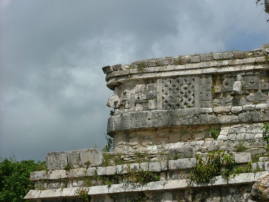 Detail of rain god masks and mat patterns decorating the tope of the terrace at Casa de Monjas at Chichen Itza