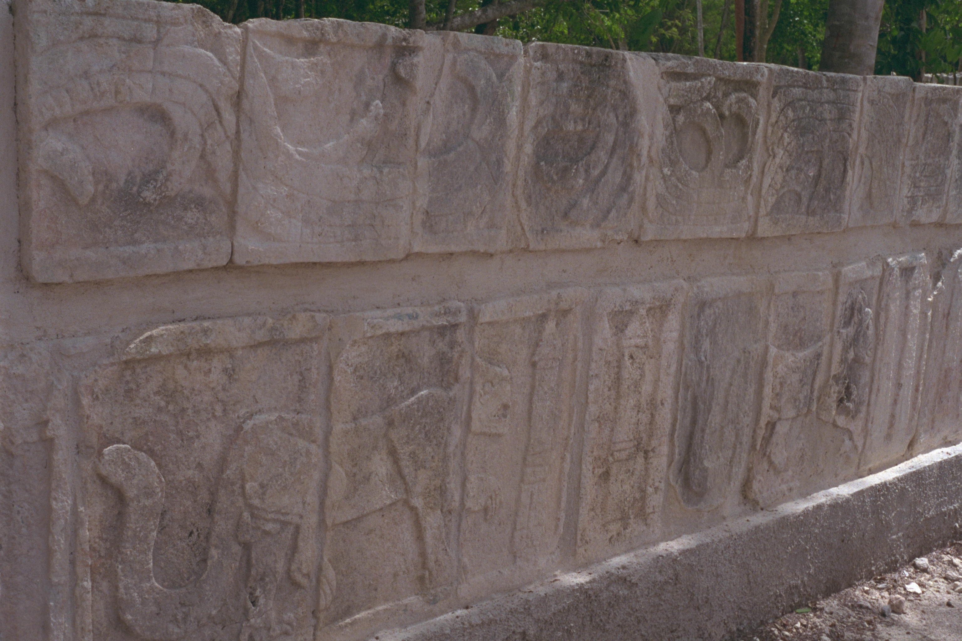 Spears and carved jaguar eating a human hearts, with details from a feathered serpent above