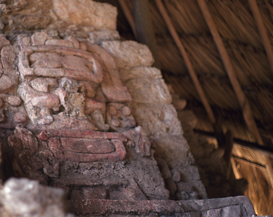 The weathered top mask on the right side of the stair