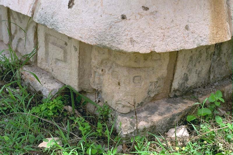 Carved ancestor head in the foundation of the throne room antichamber corner at Labna